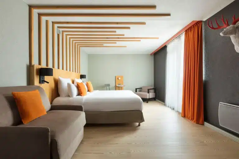 Suite Mont Blanc de l’Hôtel Les Aiglons à Chamonix, grande chambre avec canapé.