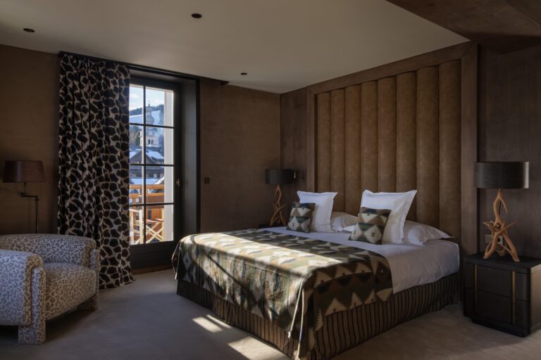 Suite Deluxe du Lodge Park Megève avec chambre double et décoration boisée