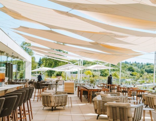 Terrasse ensoleillée du restaurant du Royal Champagne avec voiles d’ombrage et mobilier élégant